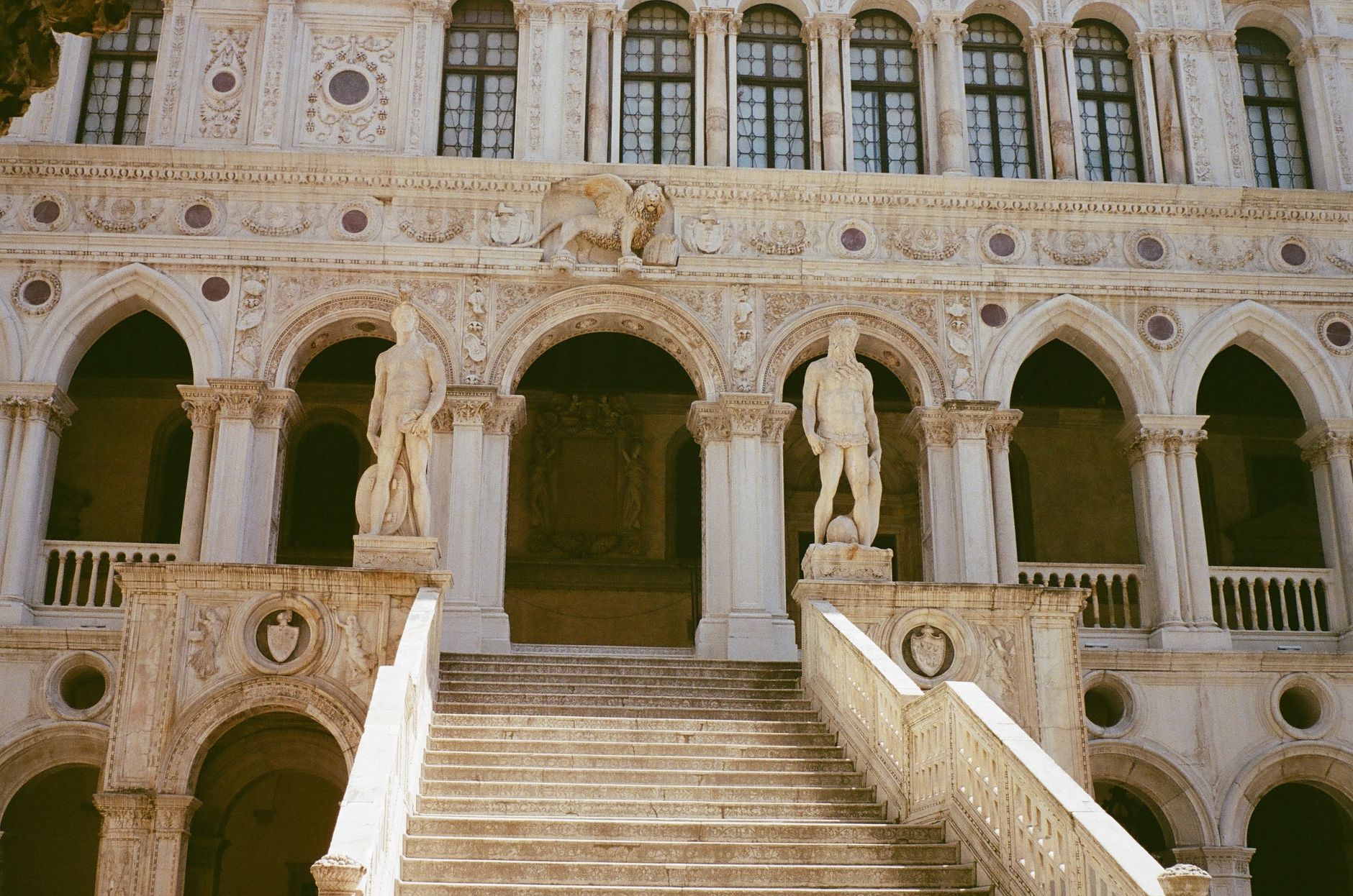 Explore the grandeur of Doge's Palace with its iconic arches and staircases in Venice, Italy.